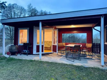 Ferienhaus mit überdachter Terrasse in der Abenddämmerung
